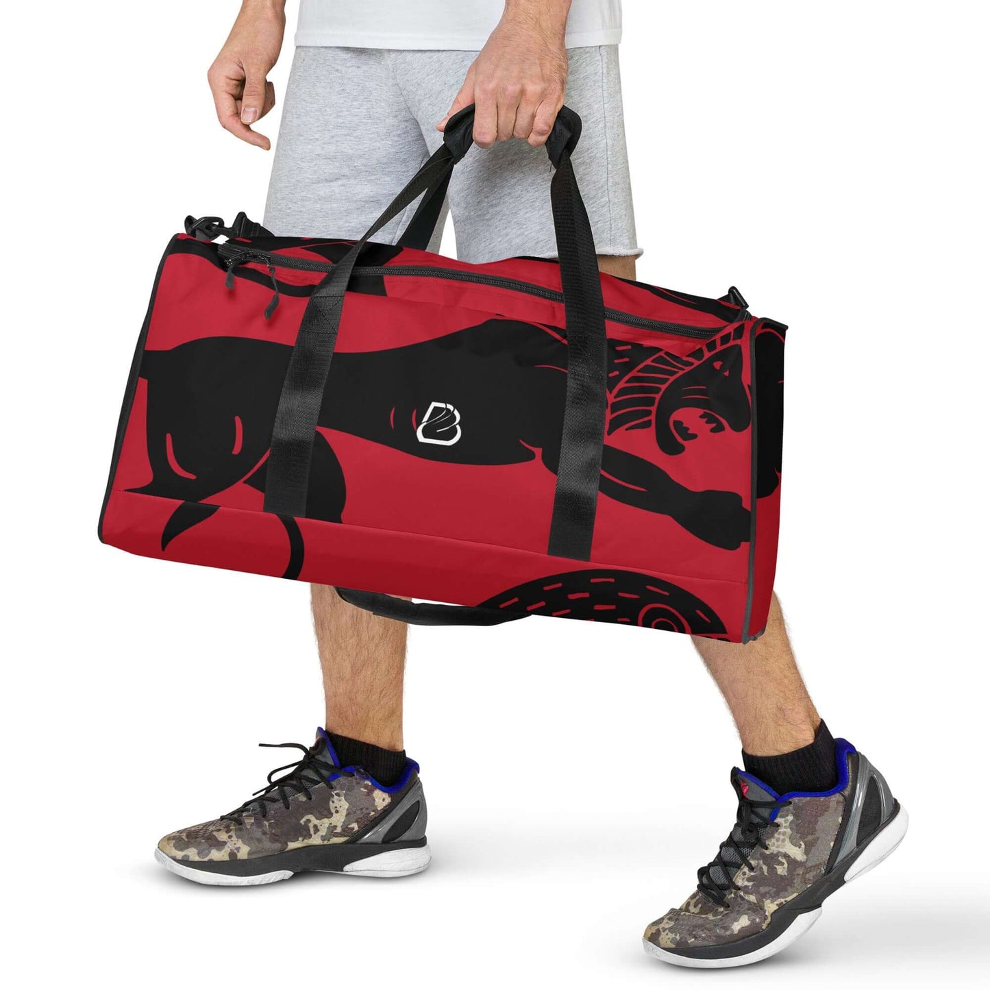 Person carrying red Weekender N°26 with black design, adjustable shoulder straps, and multiple pockets for travel or gym use.