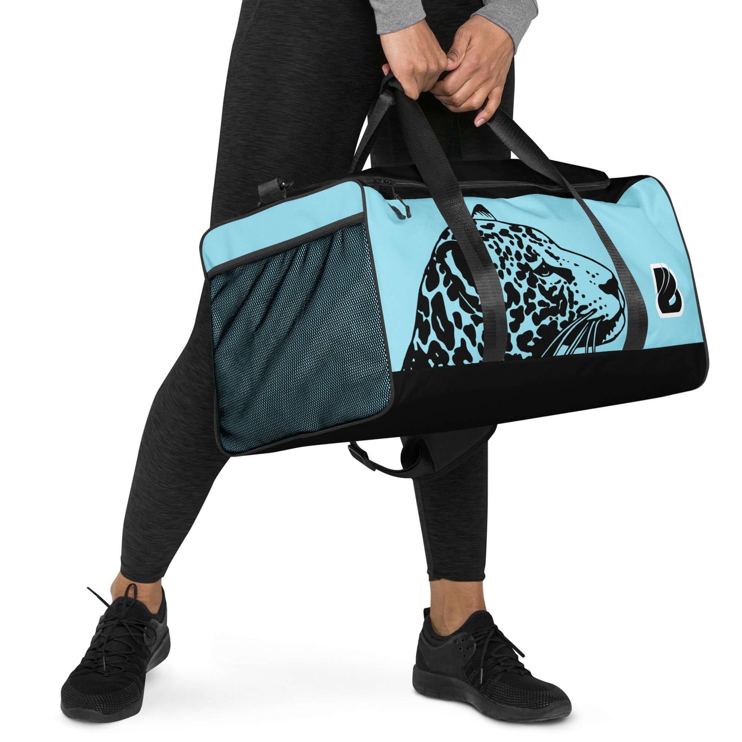 Person carrying Weekender N°27 bag with leopard design, ideal for travel, daily use, or gym, featuring multiple pockets and padded straps.