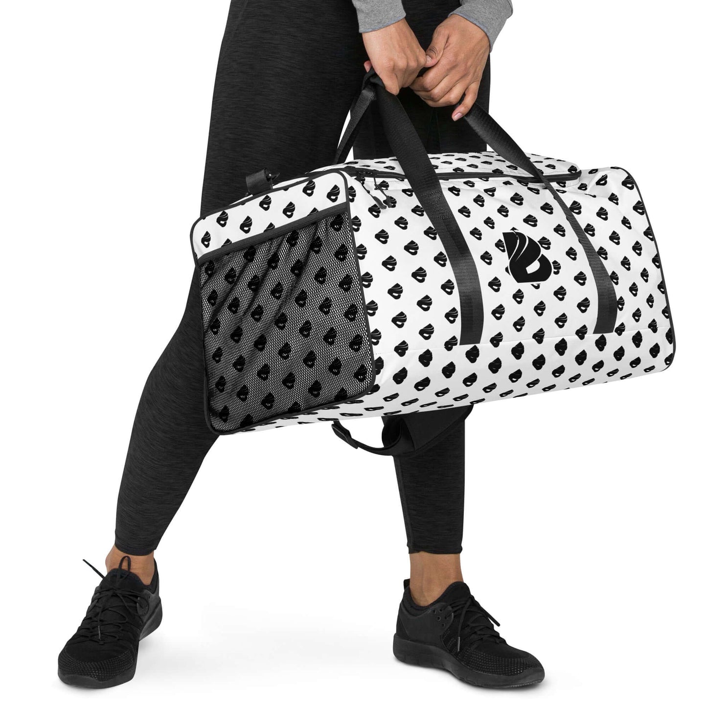 Person carrying Weekender N°30 duffel bag with black and white pattern, ideal for travel, errands, and gym, padded straps visible.