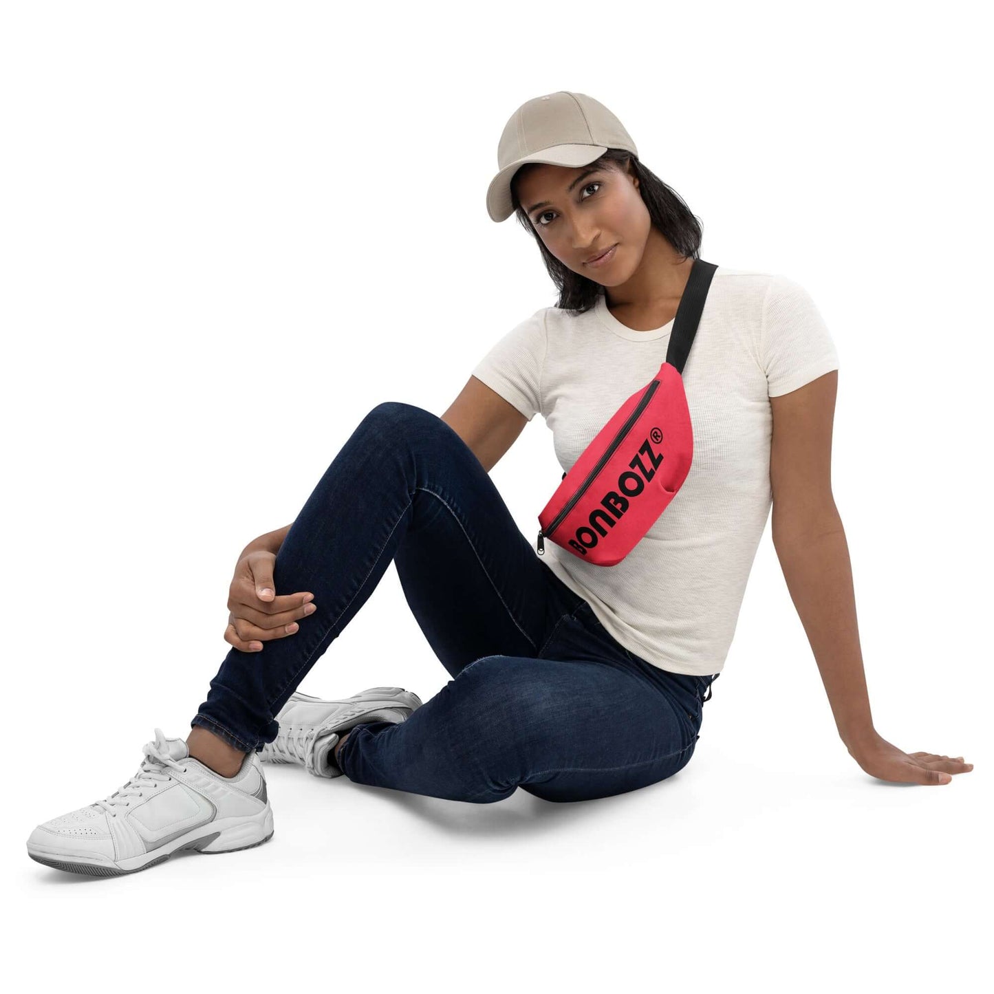 Woman wearing pink Gürteltasche N°29, sitting casually in jeans and sneakers, showcasing the adjustable strap and stylish design.