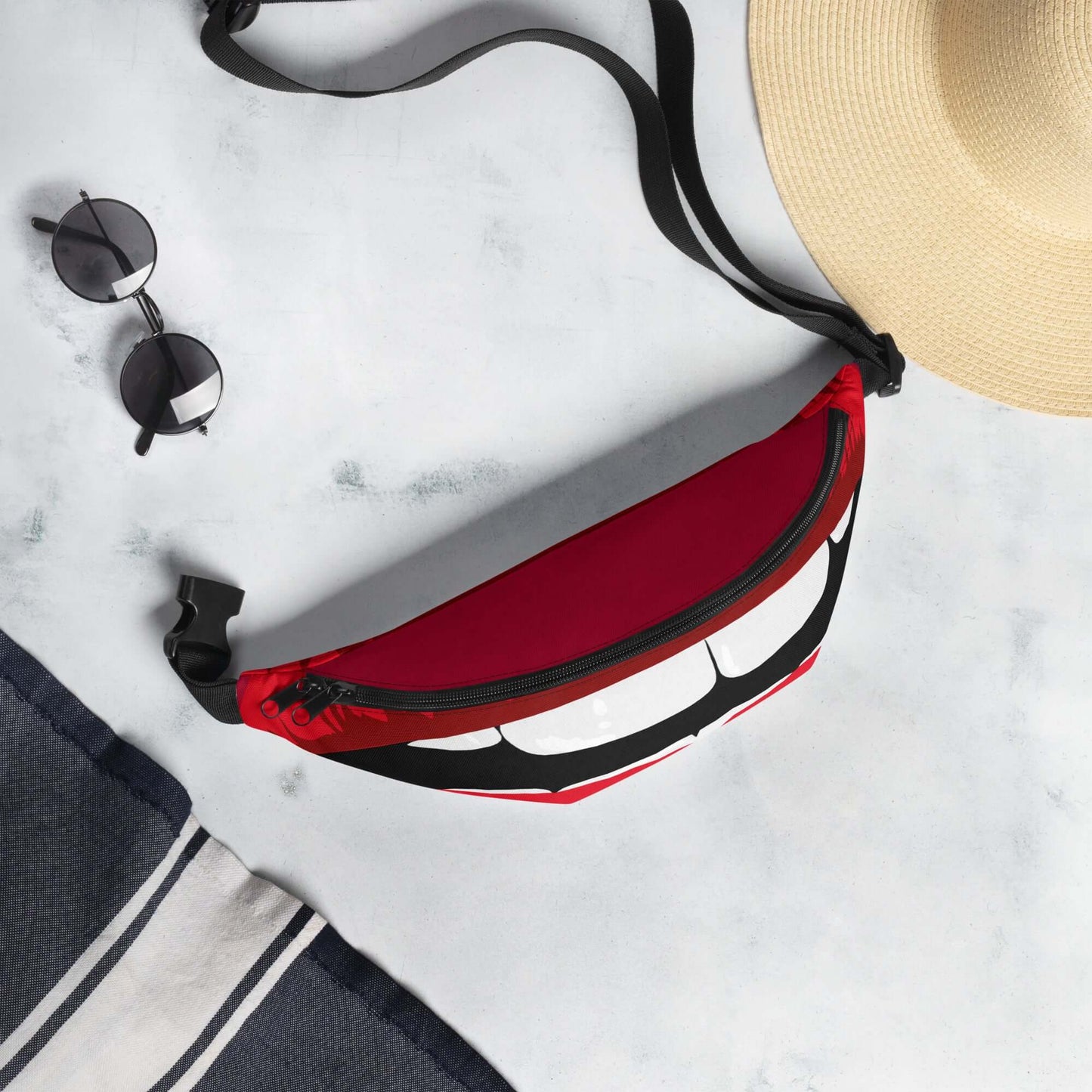 Gürteltasche N°30 in red with adjustable strap, ideal for travel and festivals, placed with sunglasses and hat.