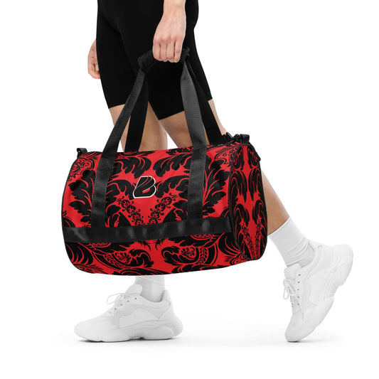 Person carrying Allover-Print-Sporttasche N°5, a red and black sports bag, made of durable, waterproof polyester, ideal for fitness.