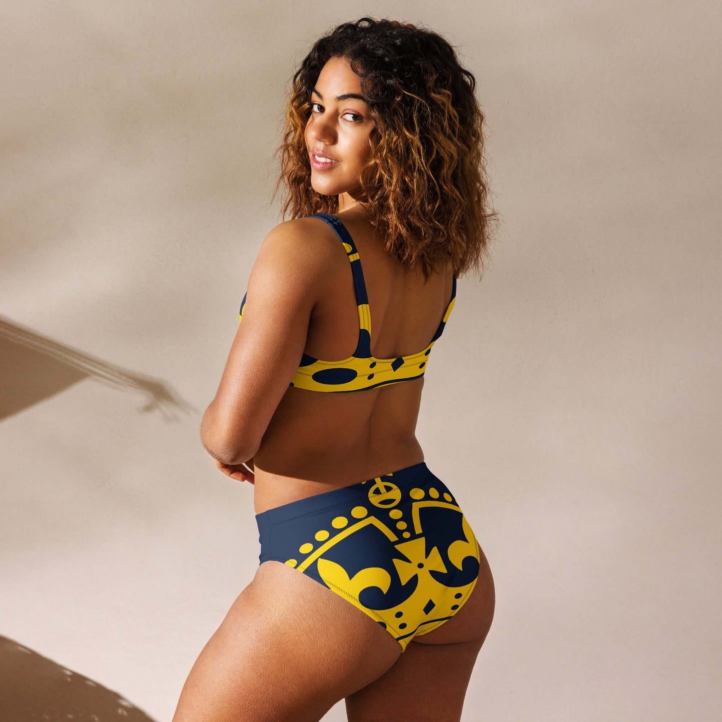 Model wearing Recycelter Allover High Waist Bikini N°1 in blue and yellow pattern, showing back design and high waist fit.