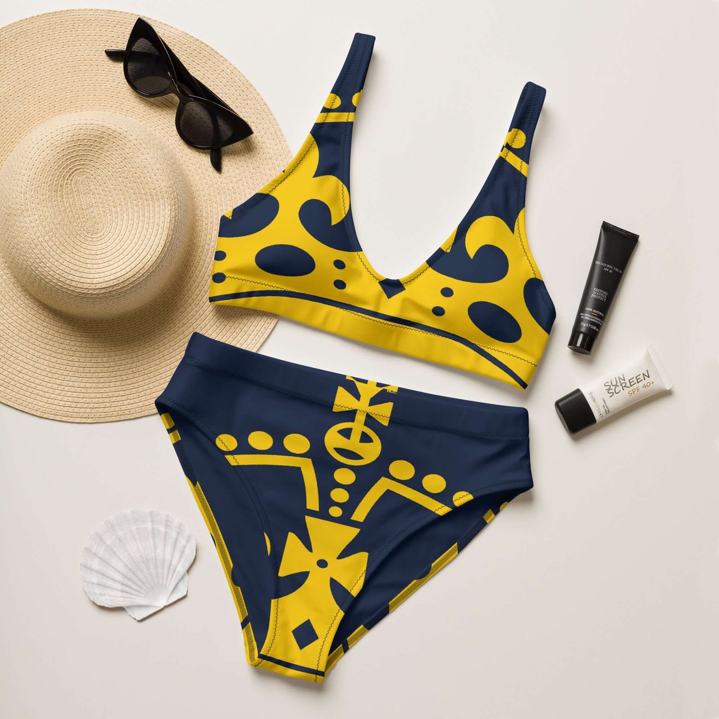 Recycelter Allover High Waist Bikini N°1 in navy and yellow with beach accessories, including sunglasses and sunscreen