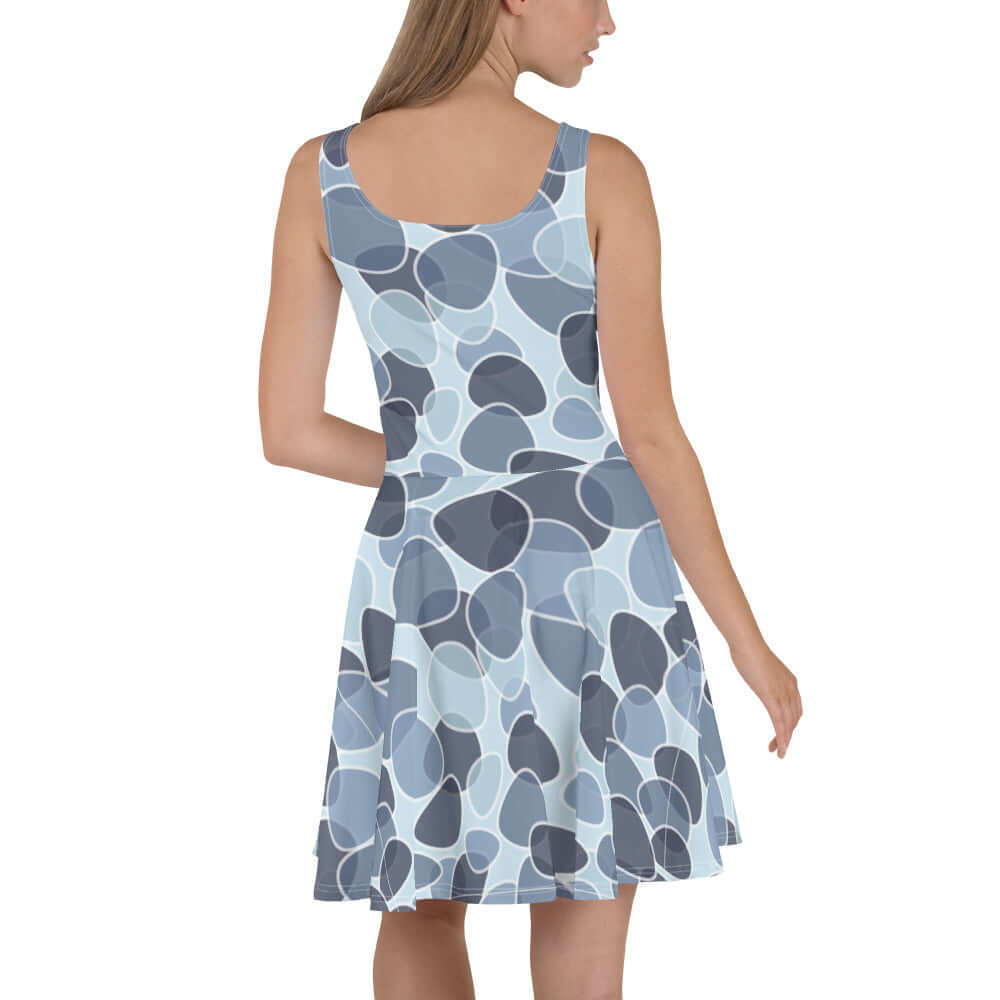 Woman wearing Skater-Kleid N°9, sleeveless design with elegant print and flared skirt, showcasing soft and elastic fabric.