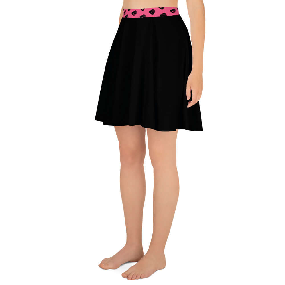 Woman wearing black Skater-Rock N°10 with pink waistband, knee-length, showcasing soft fabric and flattering A-line silhouette.
