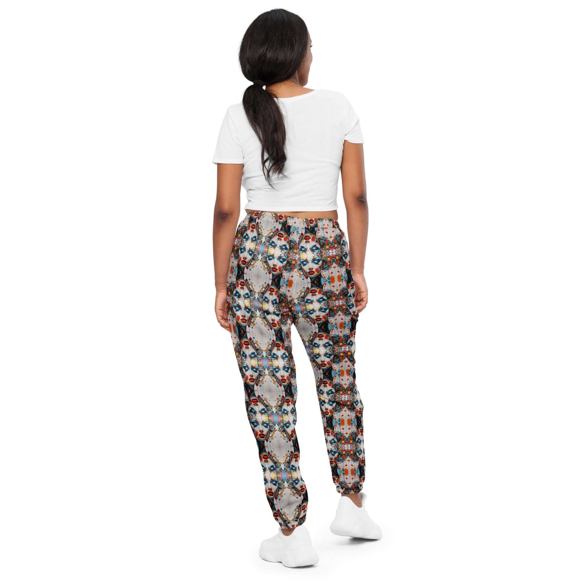 Person wearing Unisex-Trainingshose N°0 with colorful pattern and white top, showcasing a casual streetwear look.