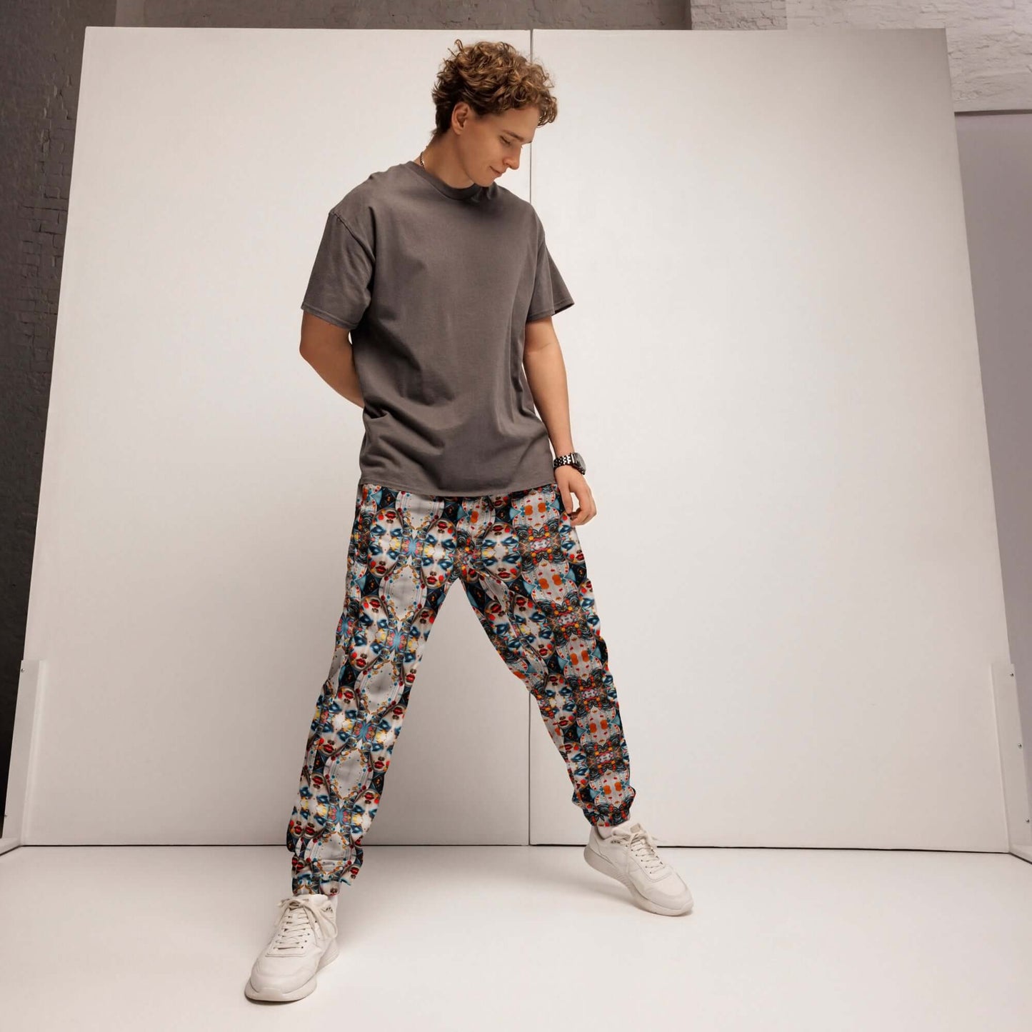 Model wearing colorful Unisex-Trainingshose N°0, highlighting elastic ankle cuffs and water-repellent material for workout or streetwear.