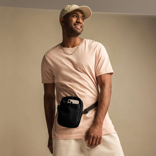 Man wearing Nützliche Umhängetasche N°0, black crossbody bag with adjustable straps, suitable for outdoor activities.