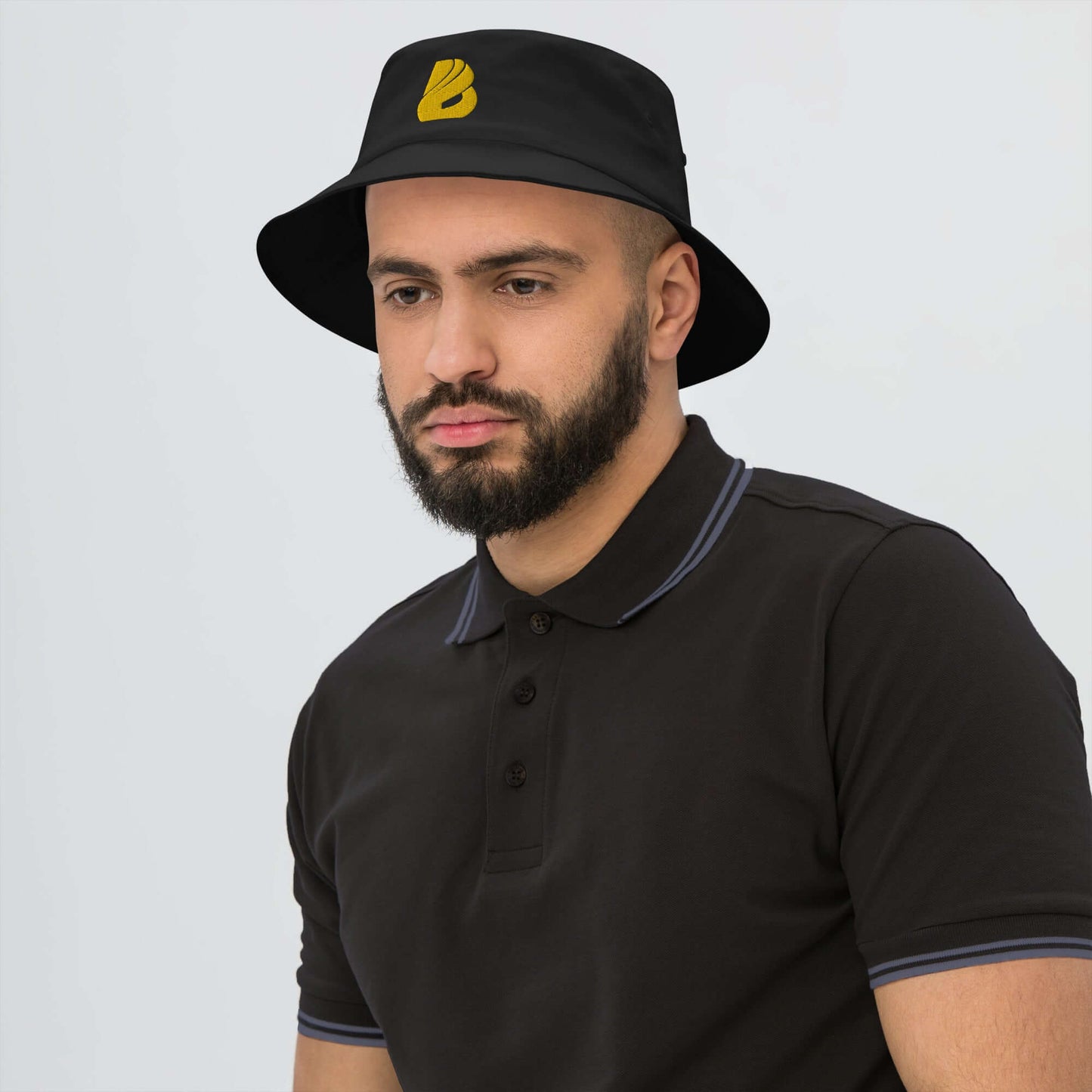 Man wearing Old School-Fischerhut N°2 black bucket hat with yellow logo, showcasing vintage style and functionality for outdoor activities.