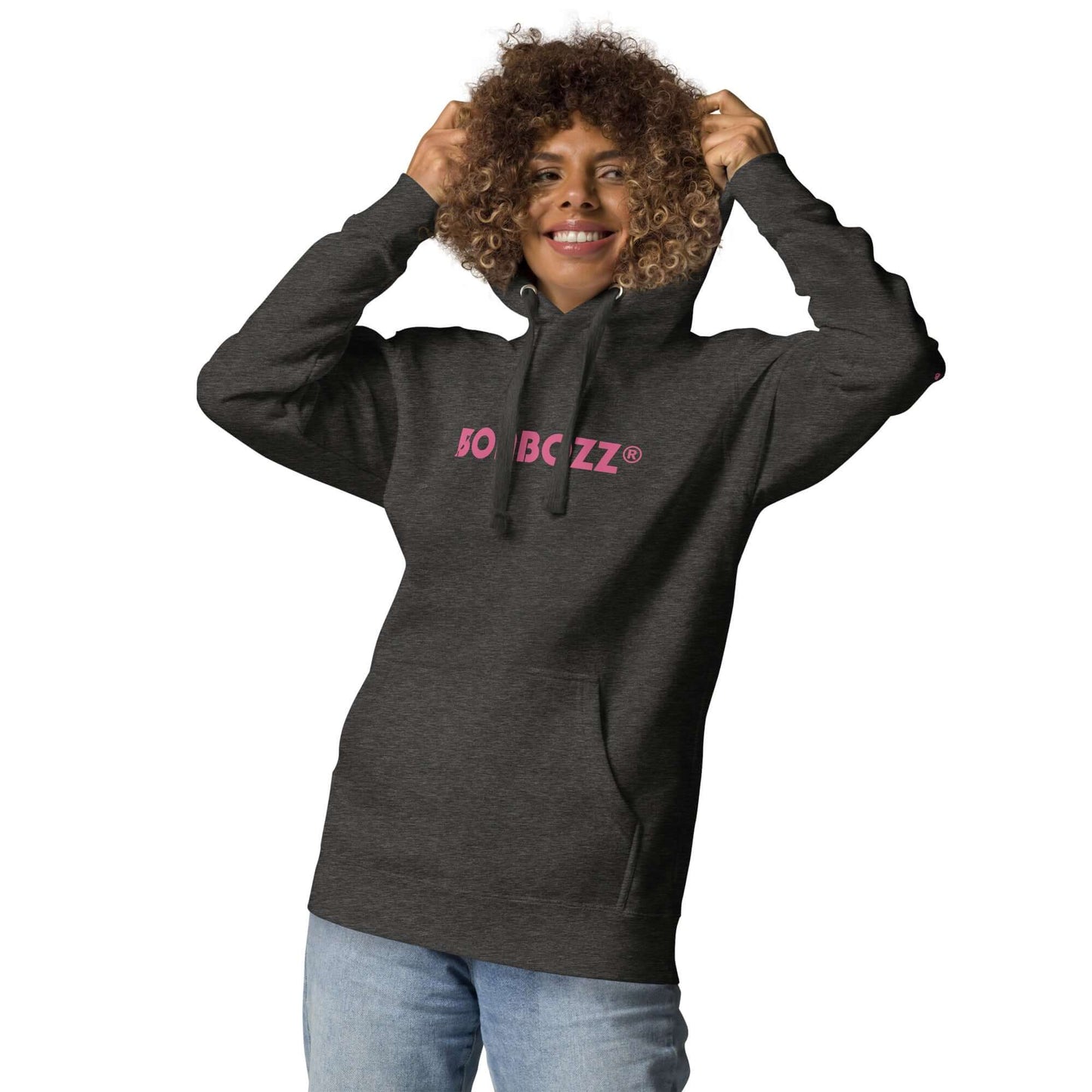 Unisex-Kapuzenpullover in dark grey, worn by a smiling person, featuring pink lettering, front pocket, and drawstring hood.