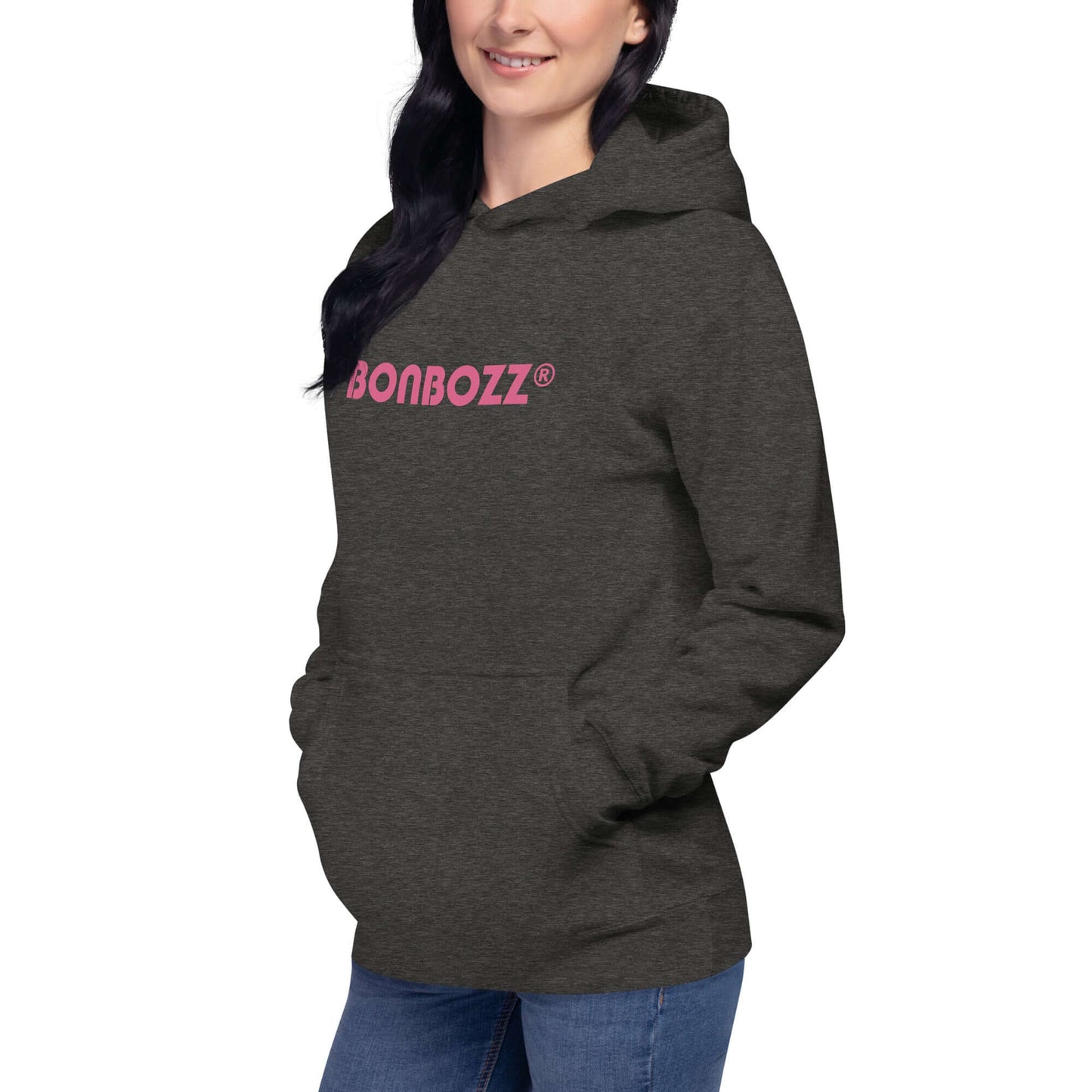 Woman wearing dark gray Unisex-Kapuzenpullover with pink graphic, featuring front pocket and hood, perfect for cool evenings.