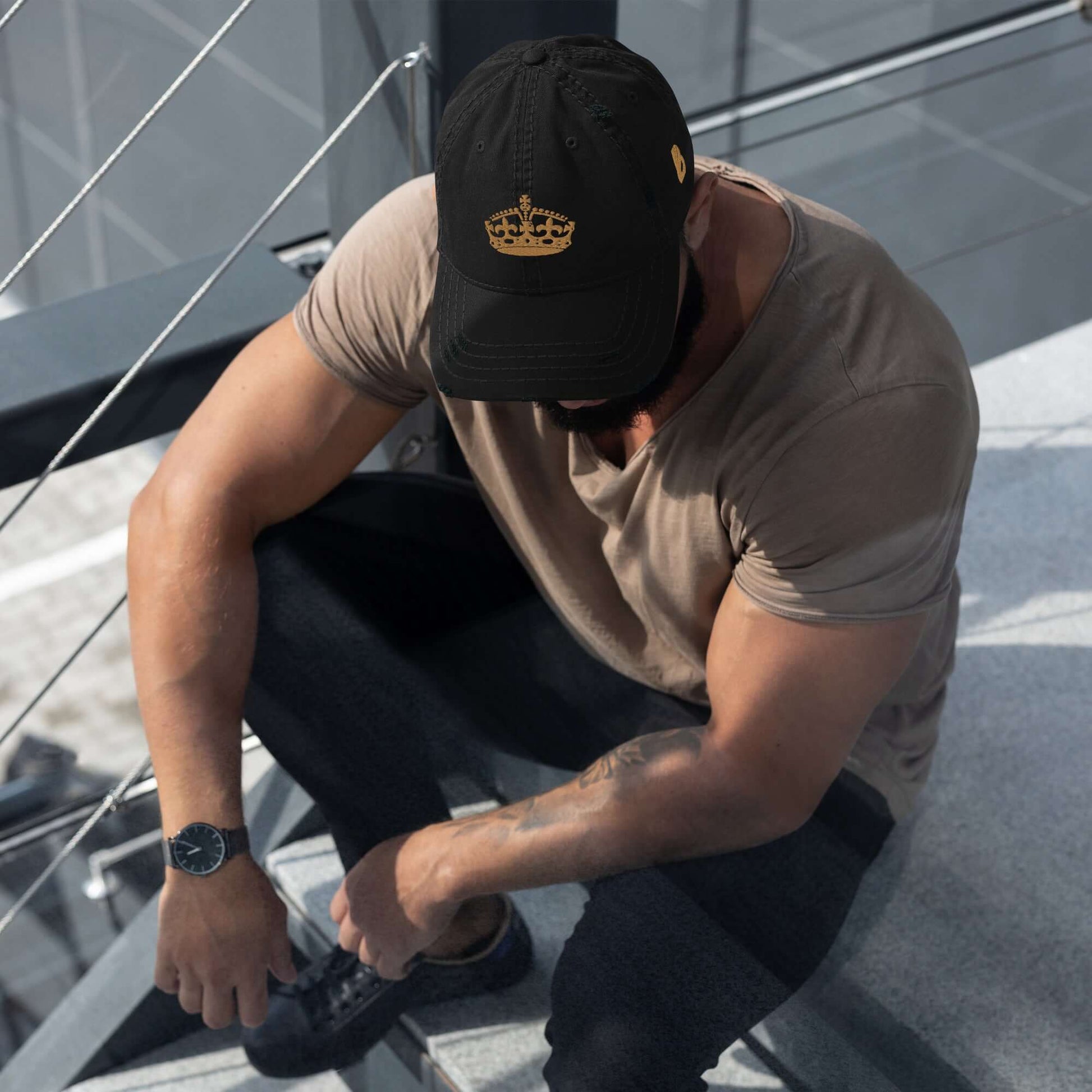 Man wearing Dad-Hat im Used-Look N°0 sitting on stairs in casual outfit.