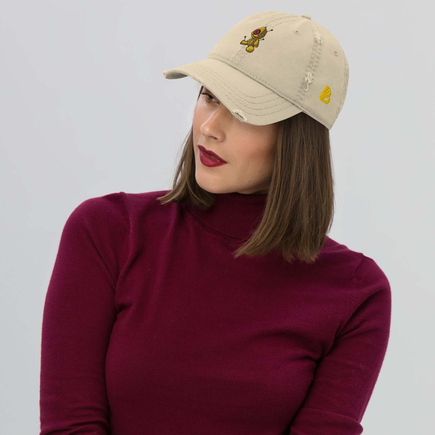 Woman wearing a stylish Dad-Hat im Used-Look N°1 with embroidered design, paired with a burgundy top, showcasing fashion-forward casual style.