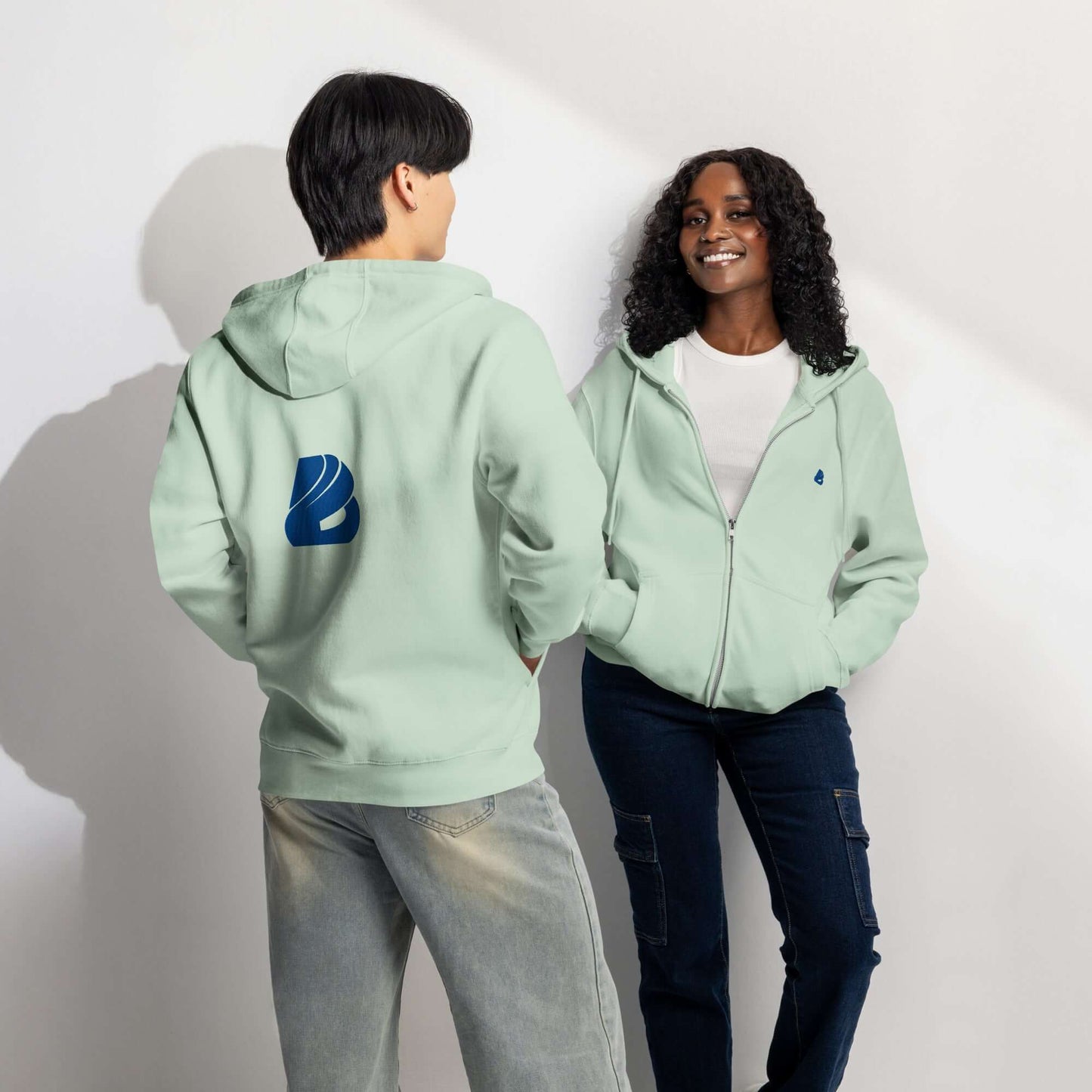 Two people wearing Premium-Zip-Hoodie in light green, showcasing back and front views, perfect for versatile style and comfort.