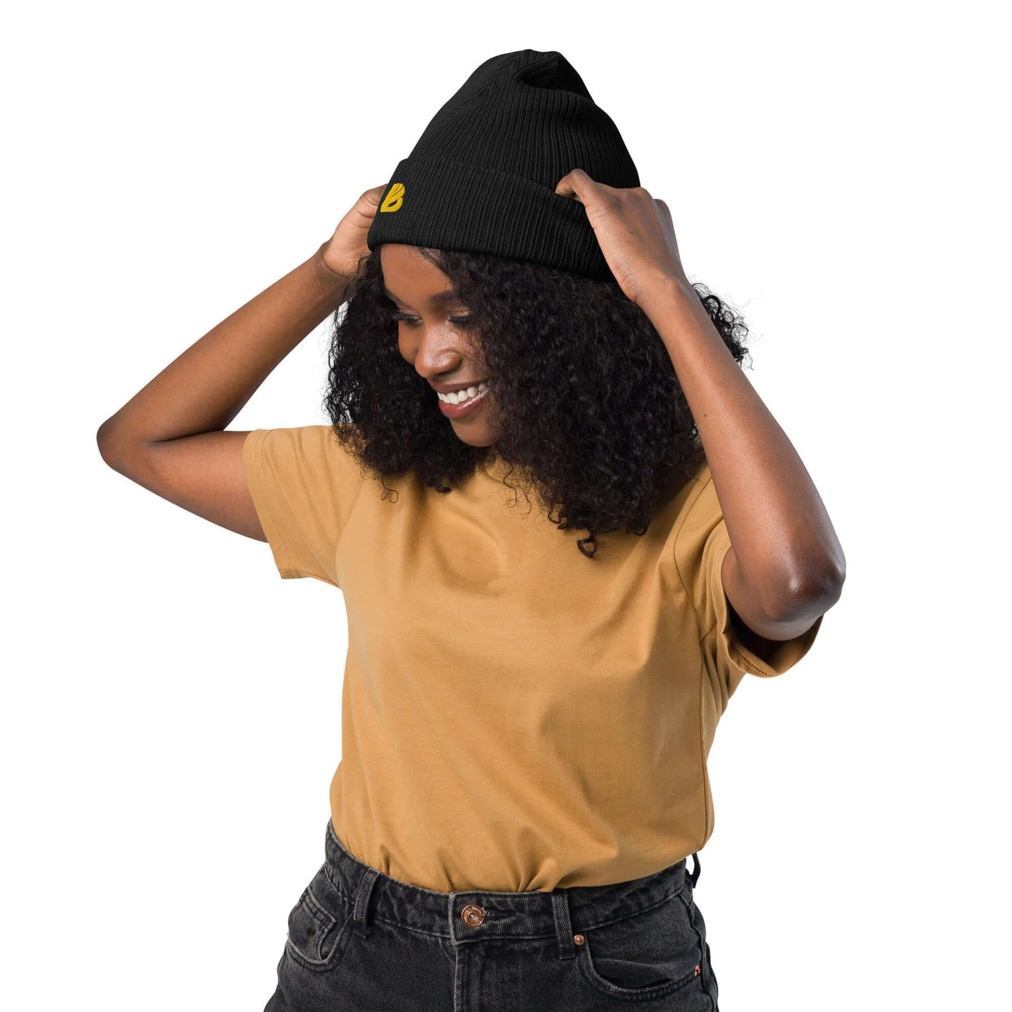 Woman wearing a black Gerippte Bio-Beanie made from organic cotton, showcasing its stylish and eco-friendly design.