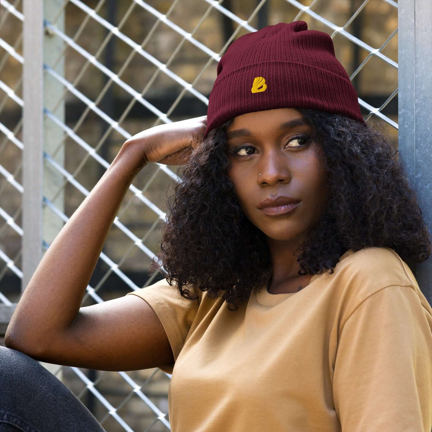 Stylish woman wearing Gerippte Bio-Beanie in maroon, made from 100% organic cotton