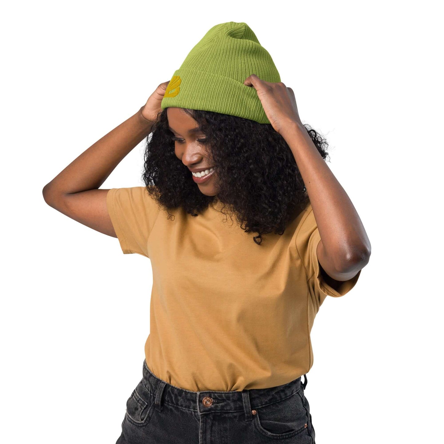 Woman wearing a green Gerippte Bio-Beanie N°1, made of 100% organic cotton, ribbed design, eco-friendly and breathable material.