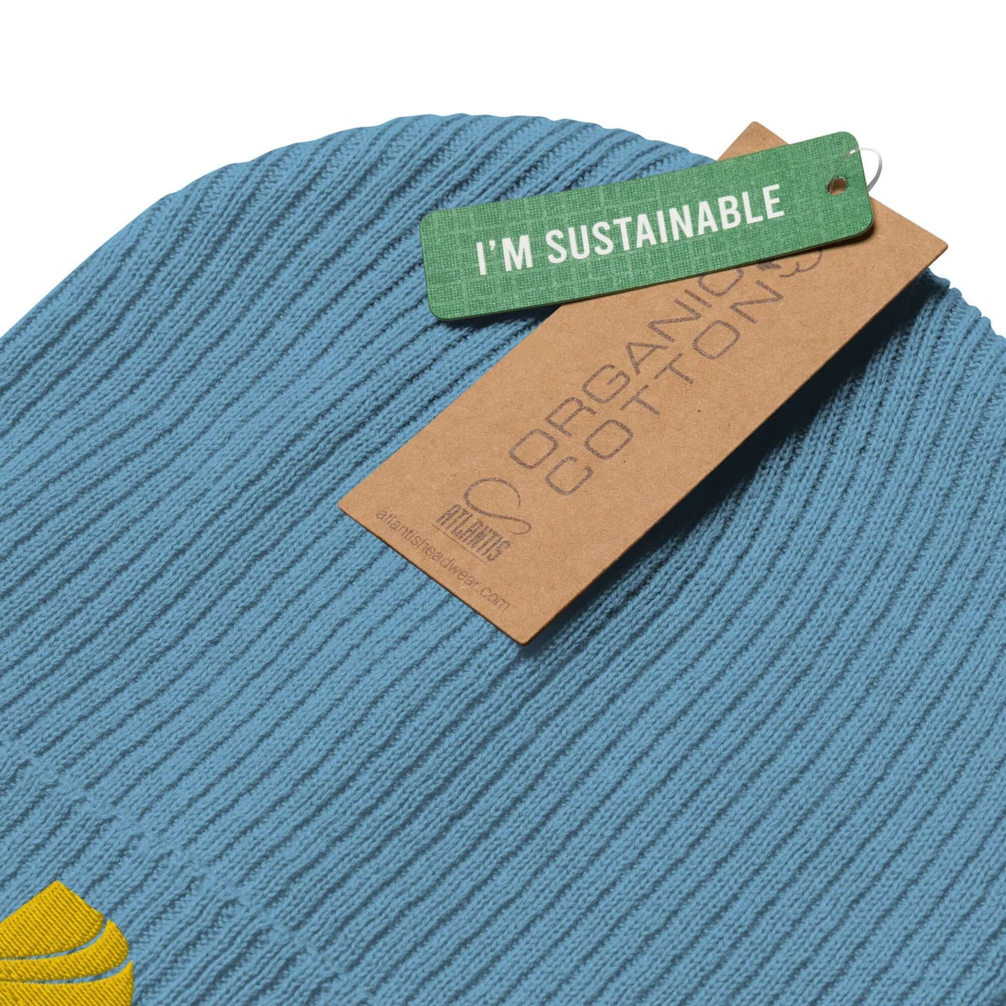 Close-up of Gerippte Bio-Beanie N°1, ribbed blue organic cotton hat with sustainability tag.
