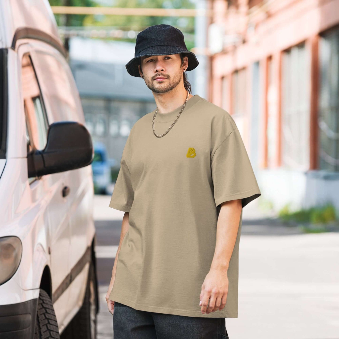 Man wearing Oversized T-Shirt mit verwaschenem Look N°1 standing next to a van in an urban setting.