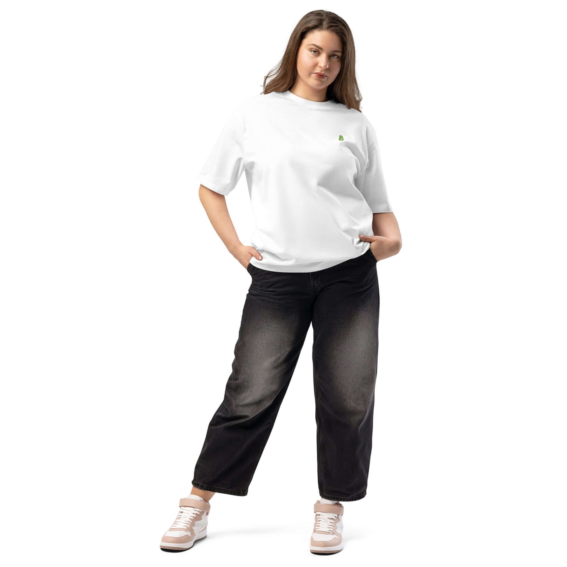 Woman wearing a white schweres oversized T-Shirt, paired with black jeans and sneakers, showcasing a casual streetwear look.