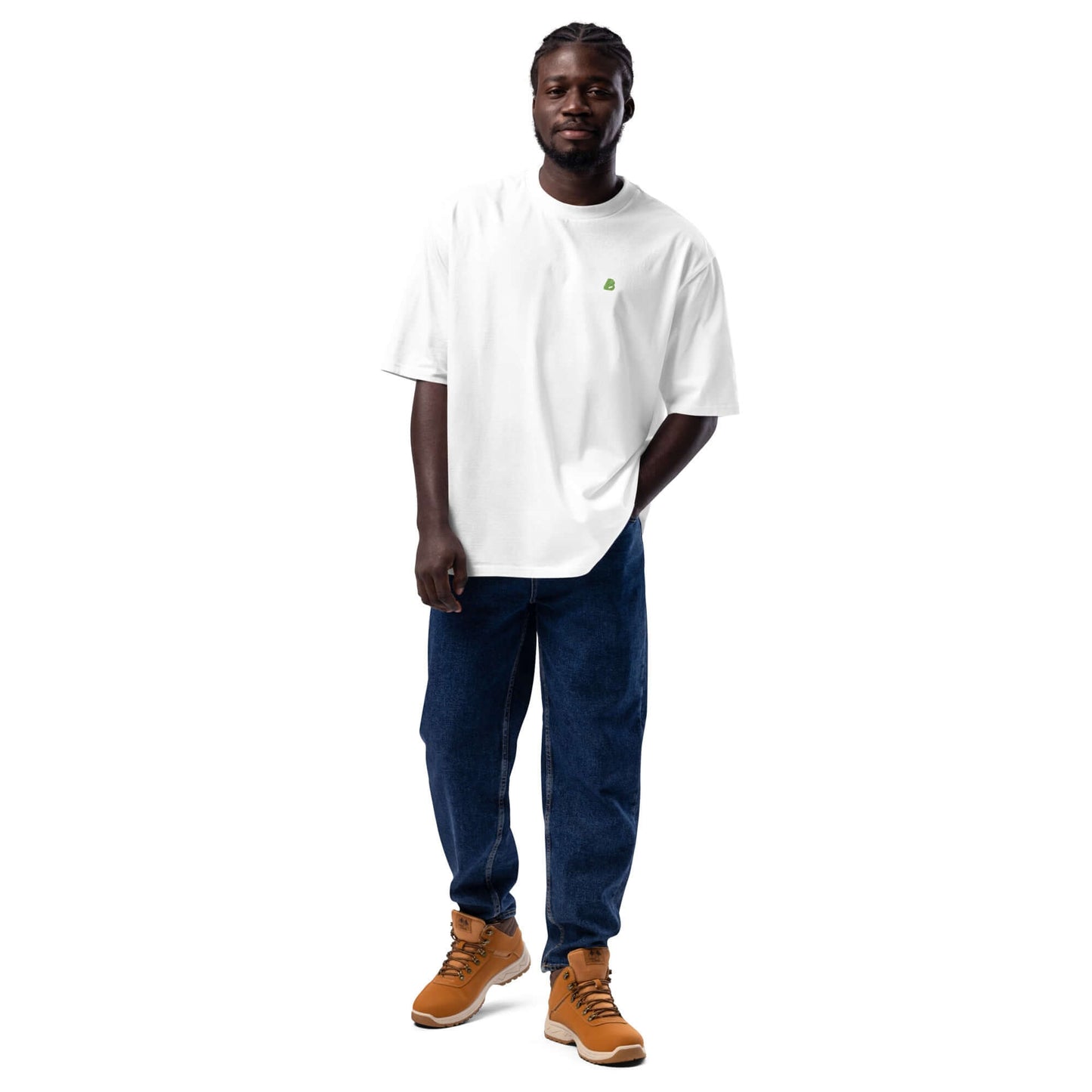 Mann trägt ein schweres oversized T-Shirt in Weiß, kombiniert mit blauen Jeans und Sneakers für einen urbanen Look.