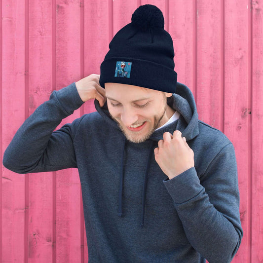 Man wearing a Bommelmütze with pom-pom against a pink wall, showcasing warmth and comfort for winter fashion.