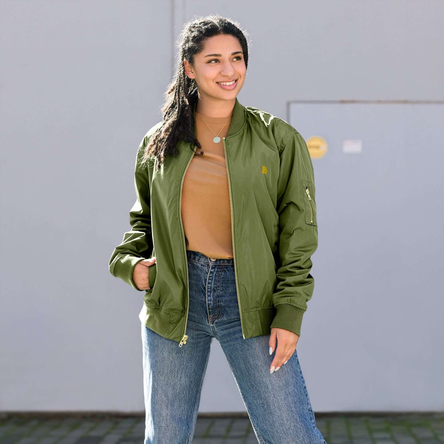 Modische Frau in einer grünen Bomberjacke aus recyceltem Material, ideal für kühle Tage.