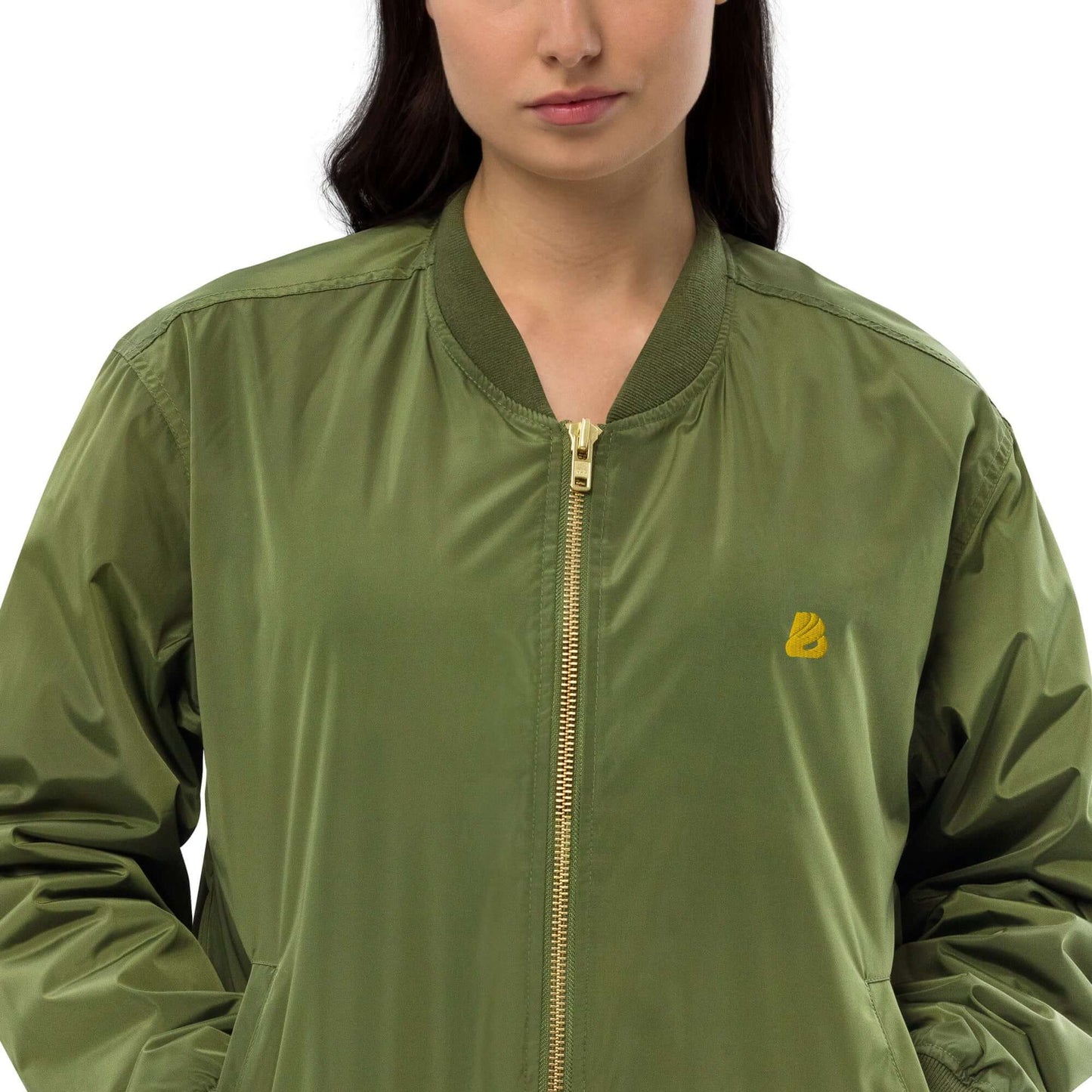 Premium recycelte Bomberjacke in Olivgrün mit goldenem Logo, entspannte Passform und Utility-Tasche am Ärmel.