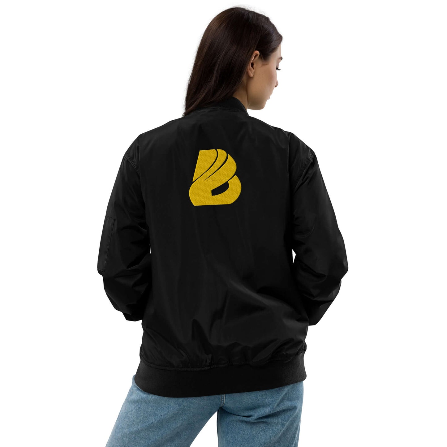 Woman wearing Premium recycled bomber jacket N°0, black with yellow logo, showing back view of eco-friendly fashion.