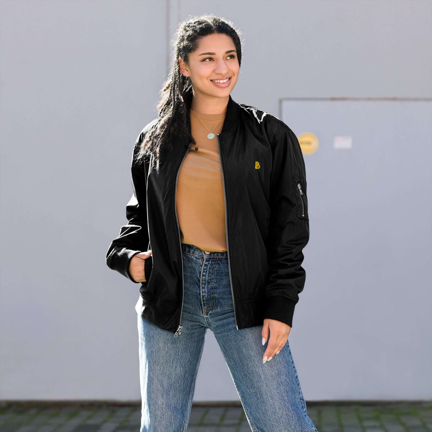 Model wearing a premium recycled bomber jacket, styled with jeans and a top, showcasing a relaxed fit.
