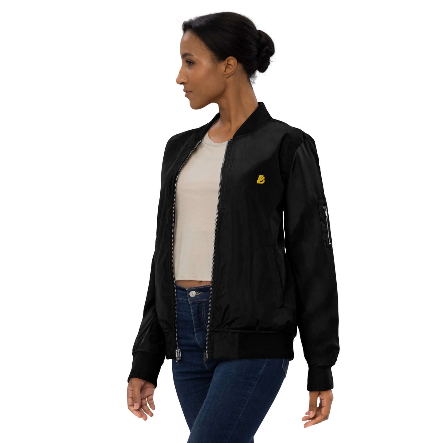 Stylish woman in a black bomber jacket made from 100% recycled polyester, showcasing a relaxed fit and utility pocket.