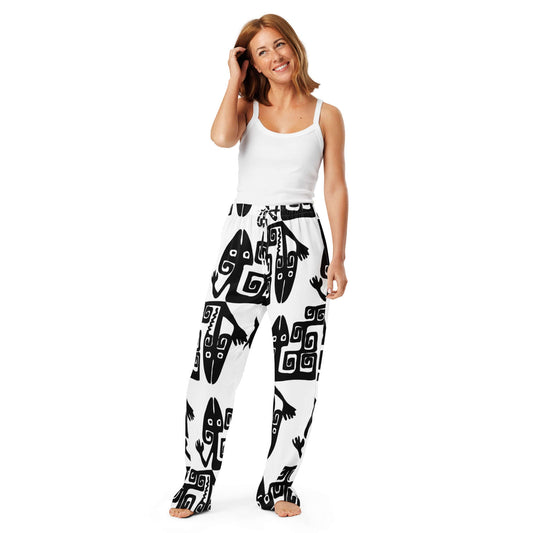 Frau trägt Pyjama-Hose für Damen mit schwarz-weißem Design, aus 100 % Polyester, entspannte Passform und seidigem Material für Komfort.