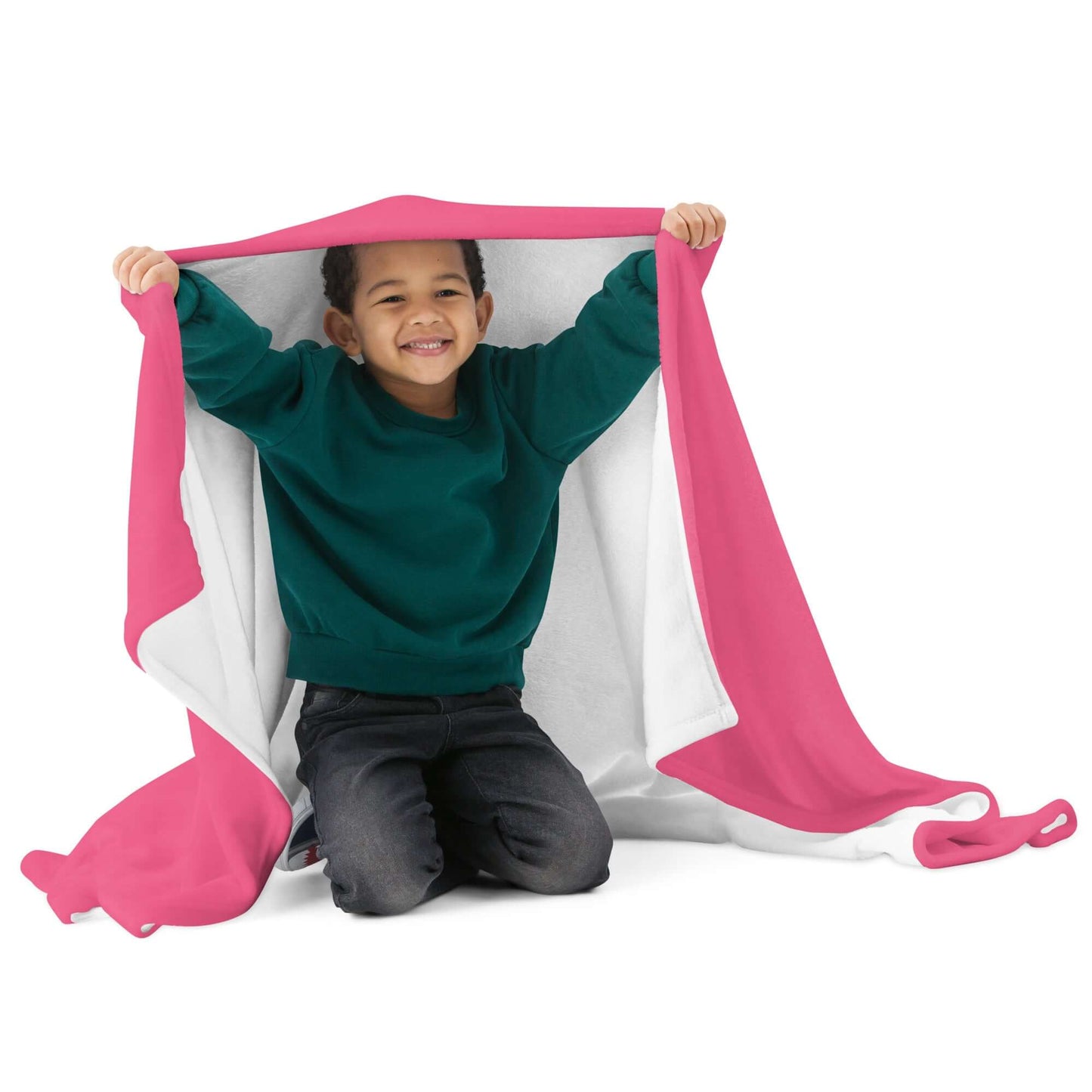 Child smiling under pink and white Tagesdecke N°3, showcasing soft, silky blanket. Features include hypoallergenic, flame retardant polyester.