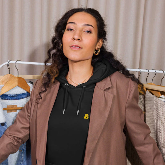 Model wearing Unisex Bio-Raglan-Hoodie N°5 paired with a brown blazer, showcasing casual yet stylish outfit.