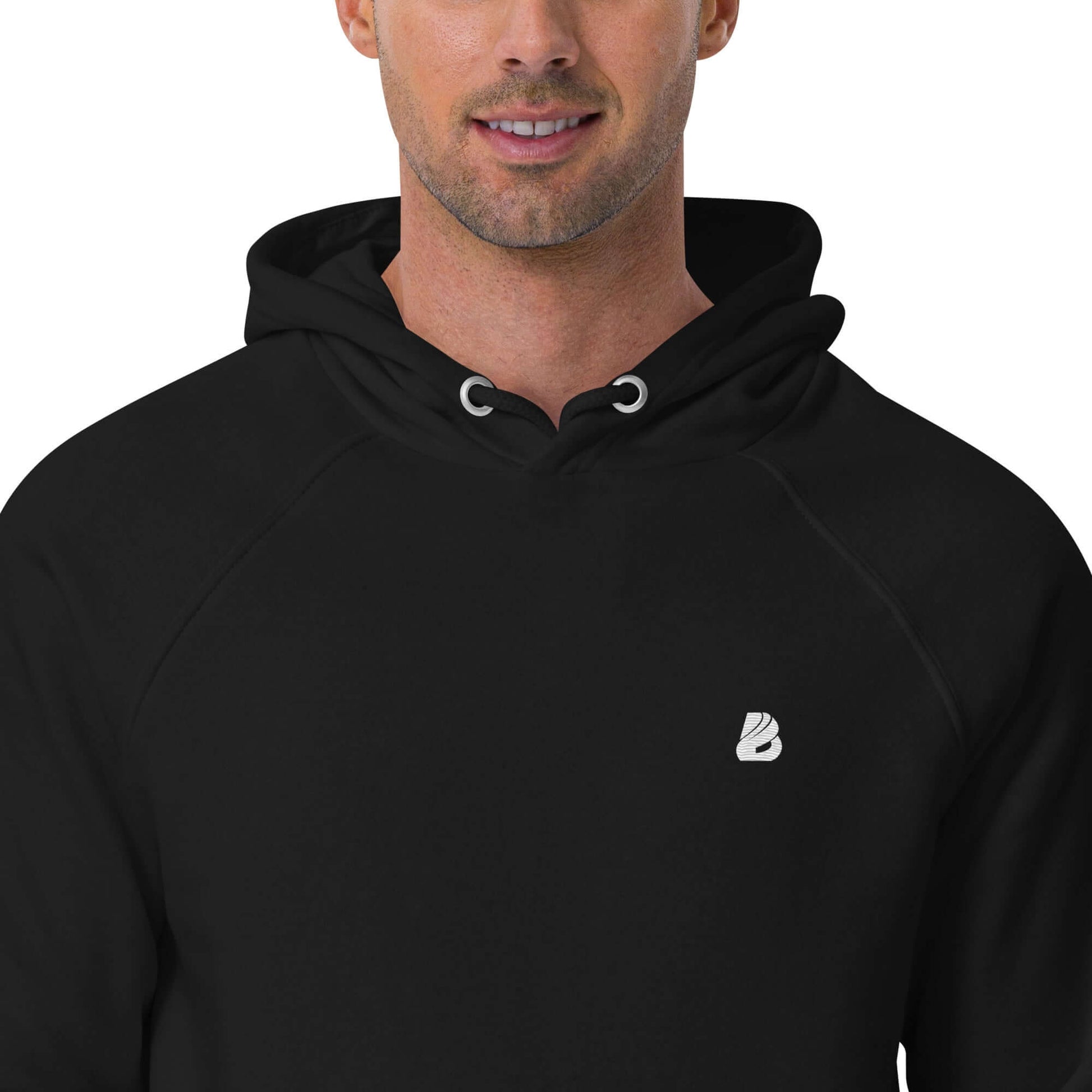 Model wearing Unisex Bio-Raglan-Hoodie N°4 in black, showcasing the soft hood and minimalist design with logo detail.