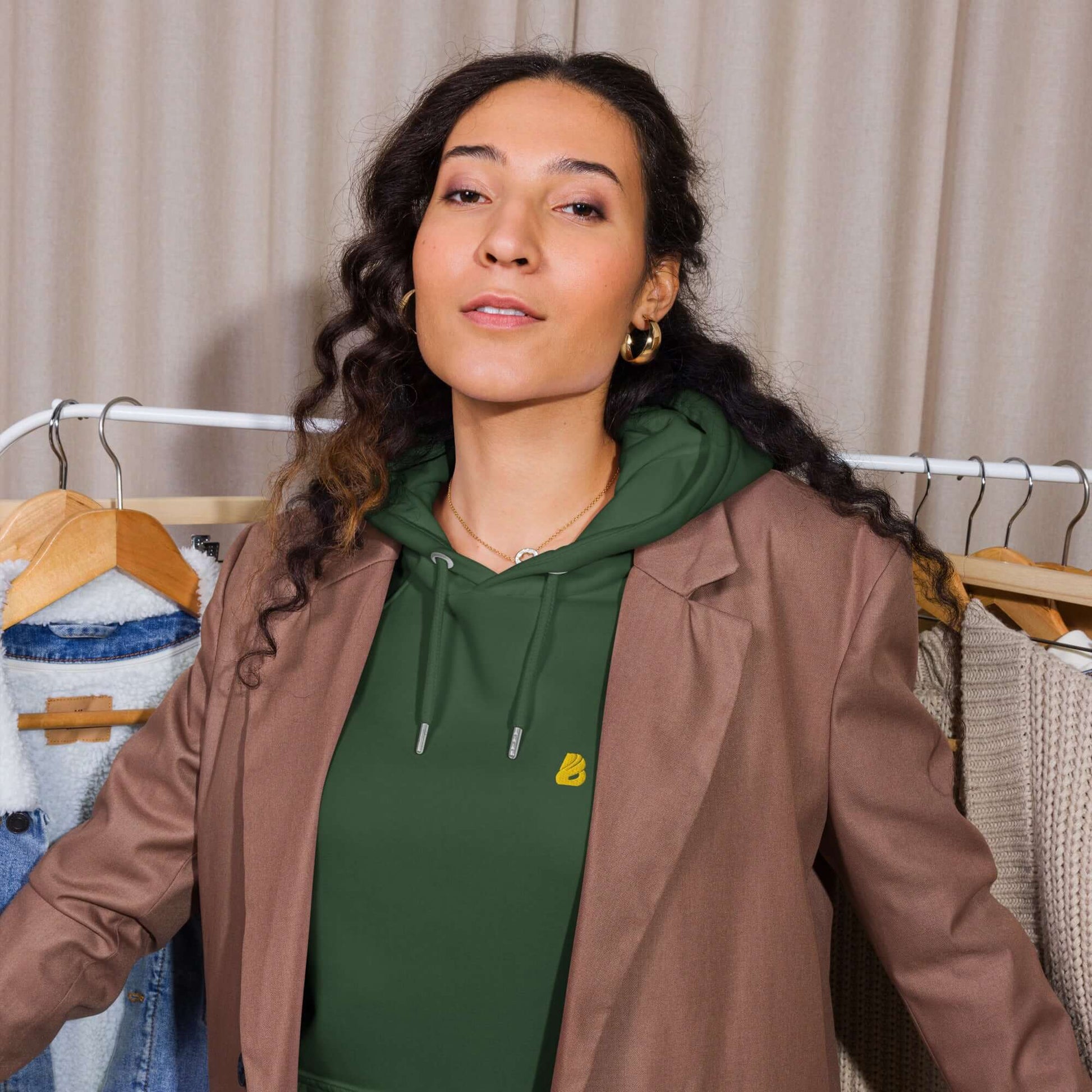 Woman wearing Unisex Bio-Raglan-Hoodie N°5 styled with a blazer, showcasing a casual yet elegant outfit choice.