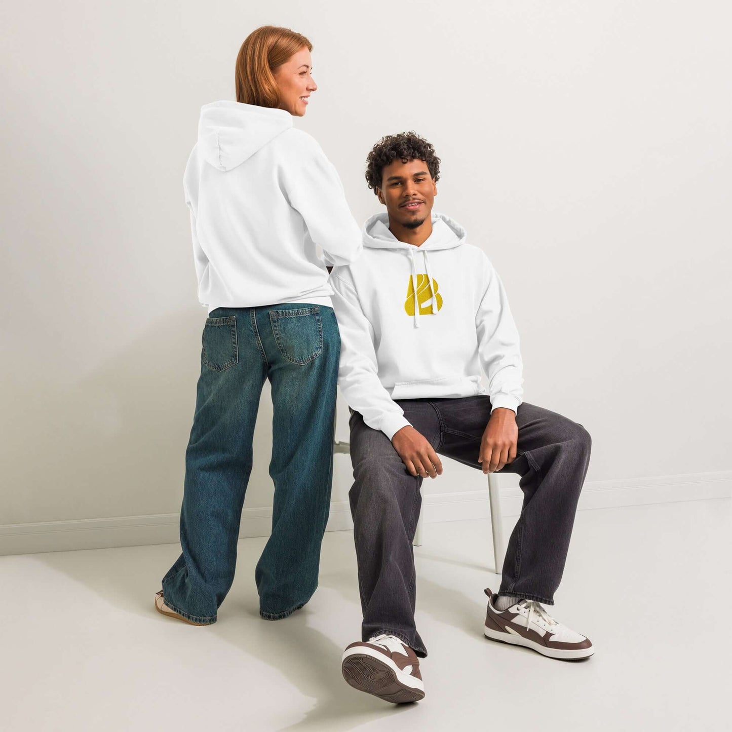 Zwei Personen tragen textilgefärbter Unisex-Hoodie in Weiß vor neutralem Hintergrund. Ideal zum Überziehen oder Entspannen.