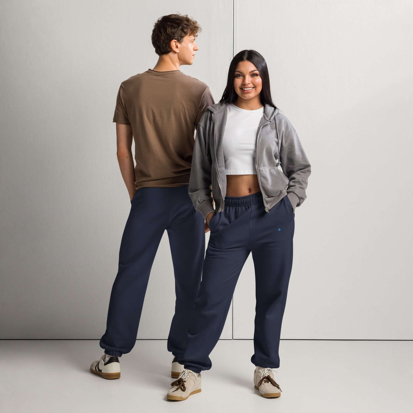 Models wearing Schwere Jogginghose in 90s style with fleece, loose street fit, featuring elastic cuffs and deep side pockets.