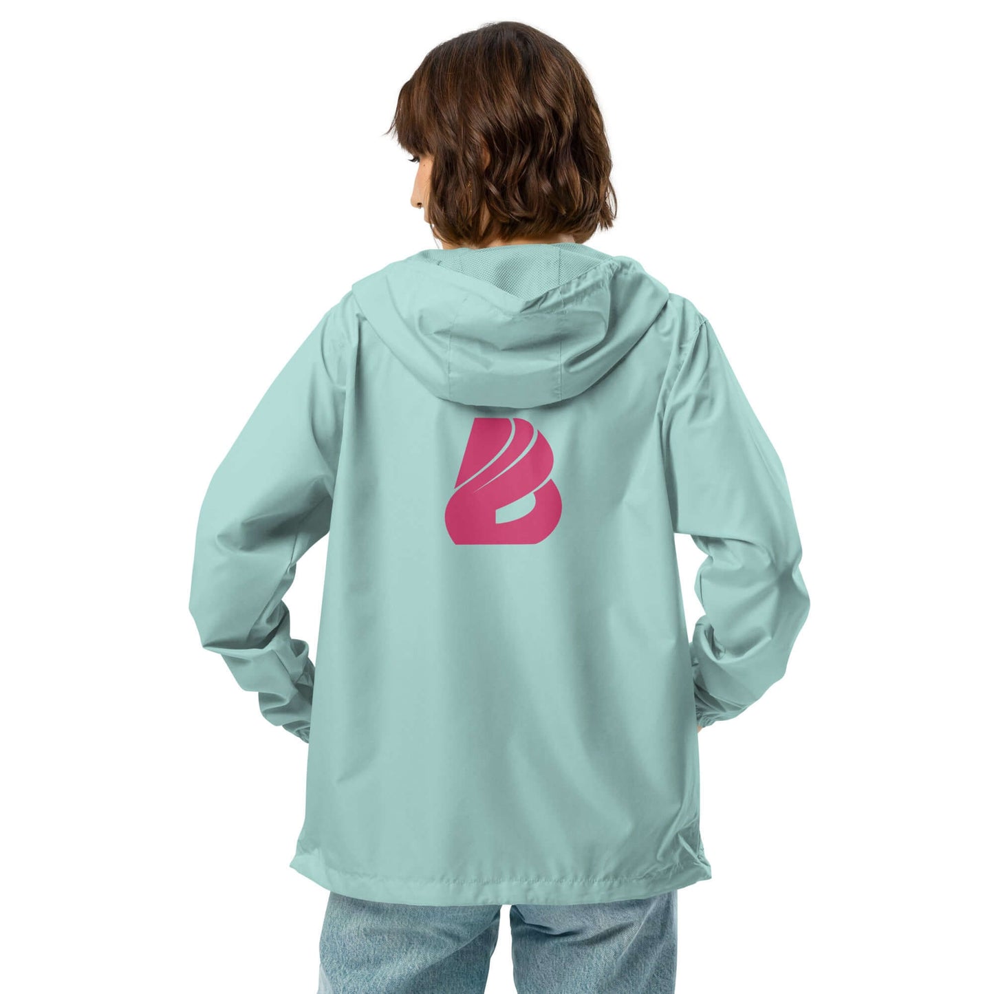 Person wearing light blue Leichter Unisex-Windbreaker mit Reißverschluss, displaying pink logo on back, suitable for outdoor adventures.