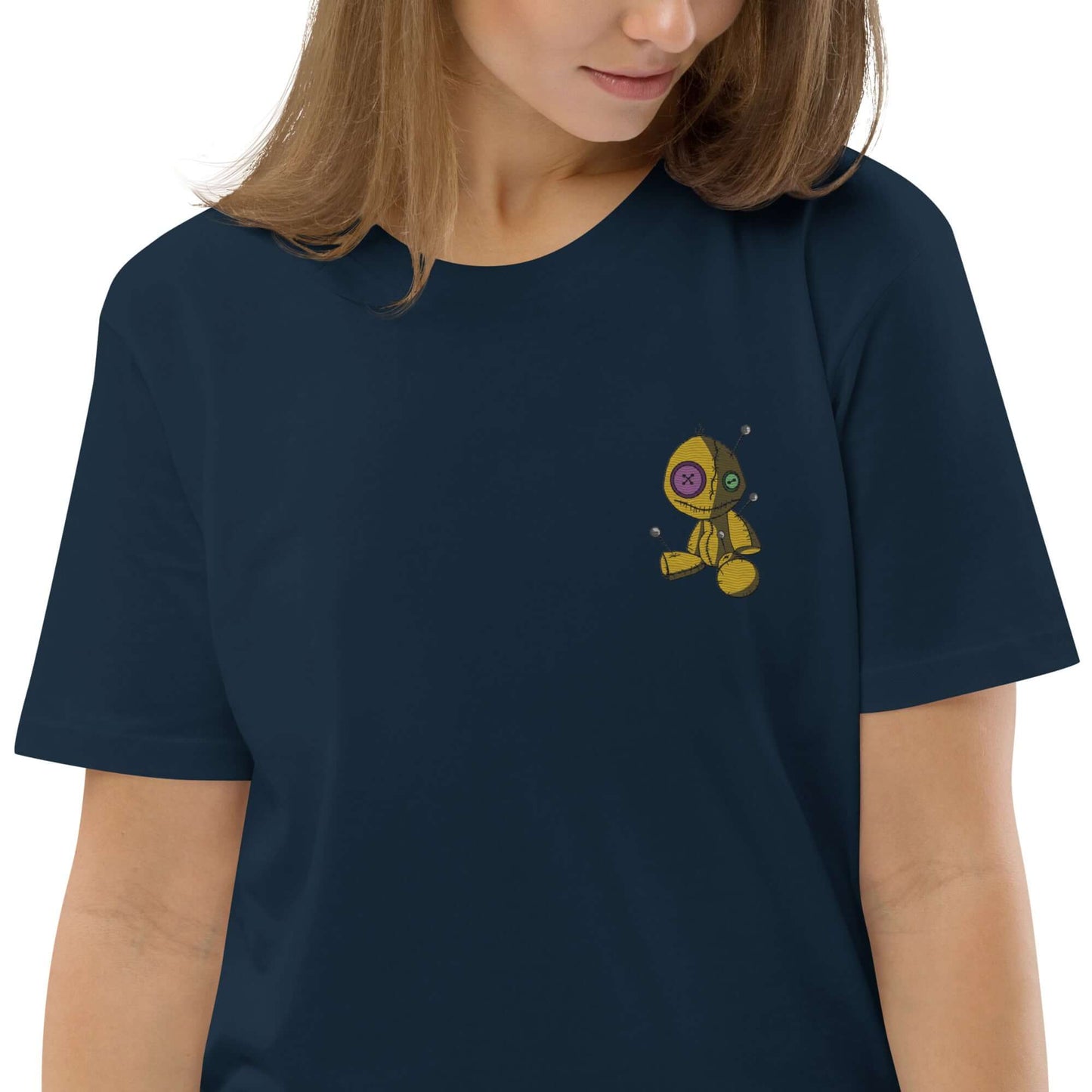 Woman wearing Unisex-Bio-Baumwoll-T-Shirt N°1 in navy with a small, colorful astronaut design on the chest.