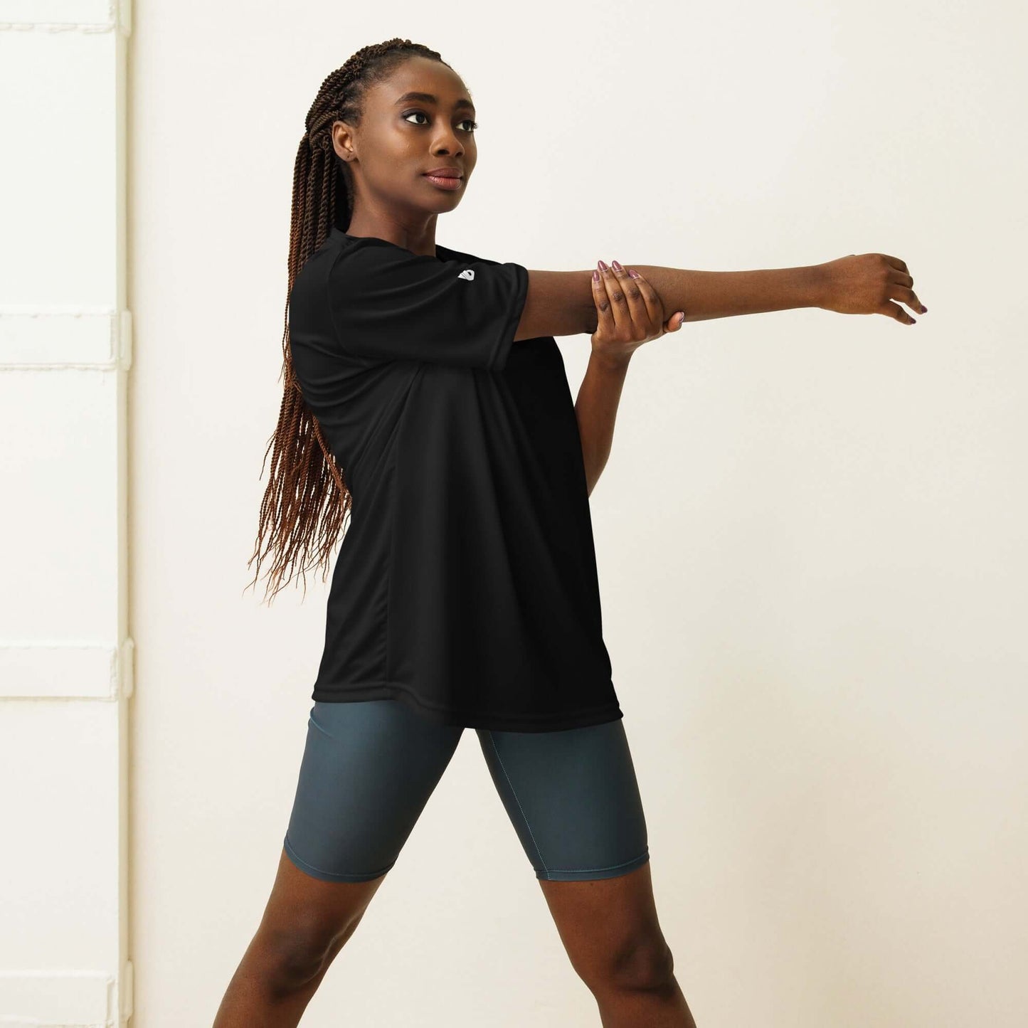 Woman stretching while wearing Unisex Performance T-Shirt mit Rundhalsausschnitt N°0 in black, ideal for fitness and outdoor activities.