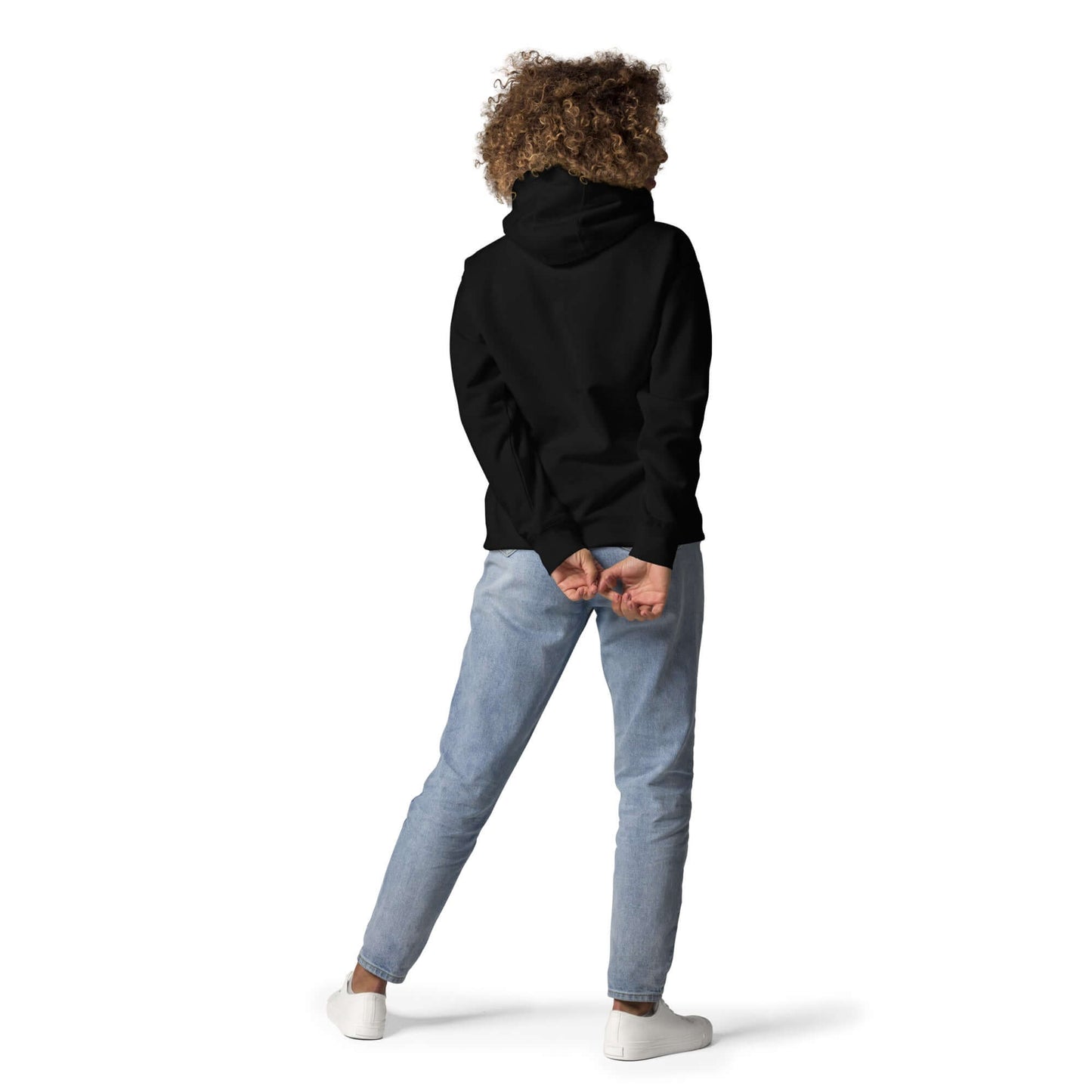 Person wearing Unisex-Kapuzenpullover N°48 in black with hood up, showcasing streetwear style from the back, paired with jeans and sneakers.