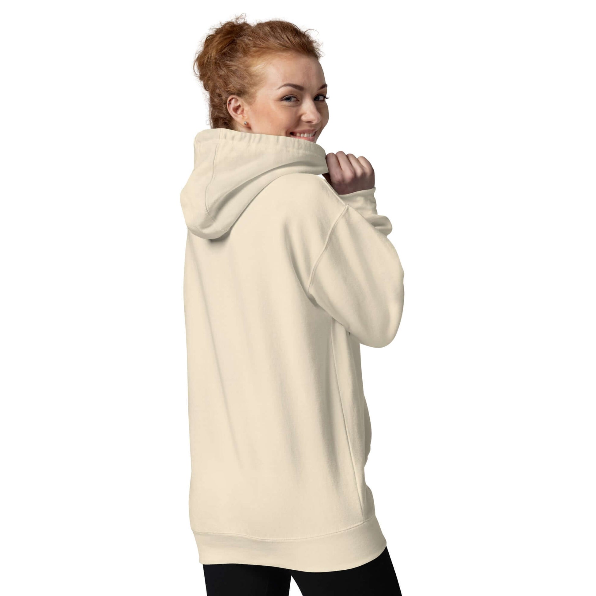 Woman wearing Unisex-Kapuzenpullover N°49 with hood up, showcasing back view in cream color.