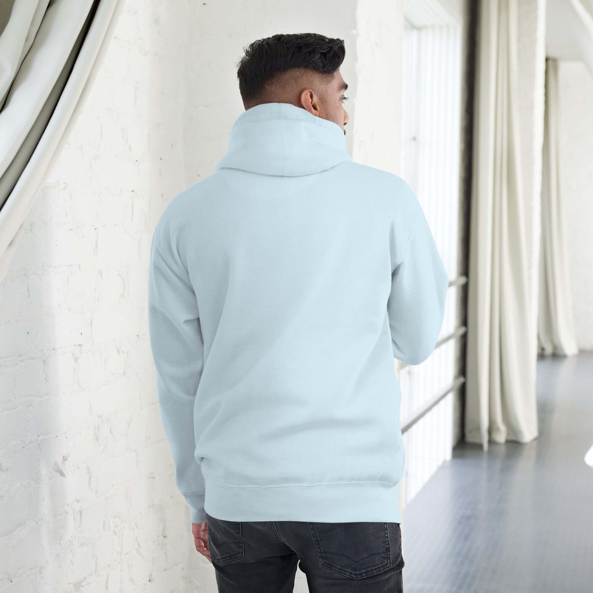 Rear view of model wearing Unisex-Kapuzenpullover N°49, showcasing soft cotton fabric and cozy hood design for cool evenings.