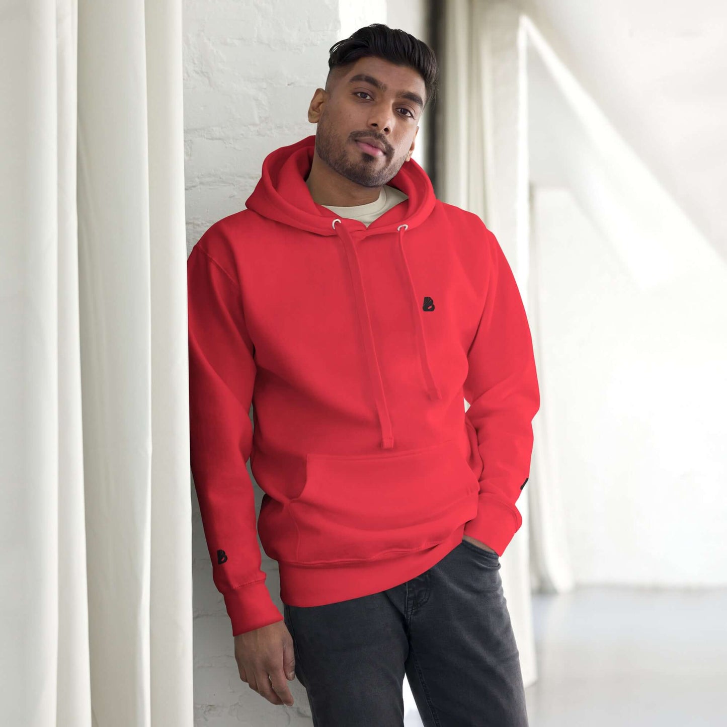 Person wearing Unisex-Kapuzenpullover N°49 in red with a cozy design and front pouch, perfect for cool evenings.