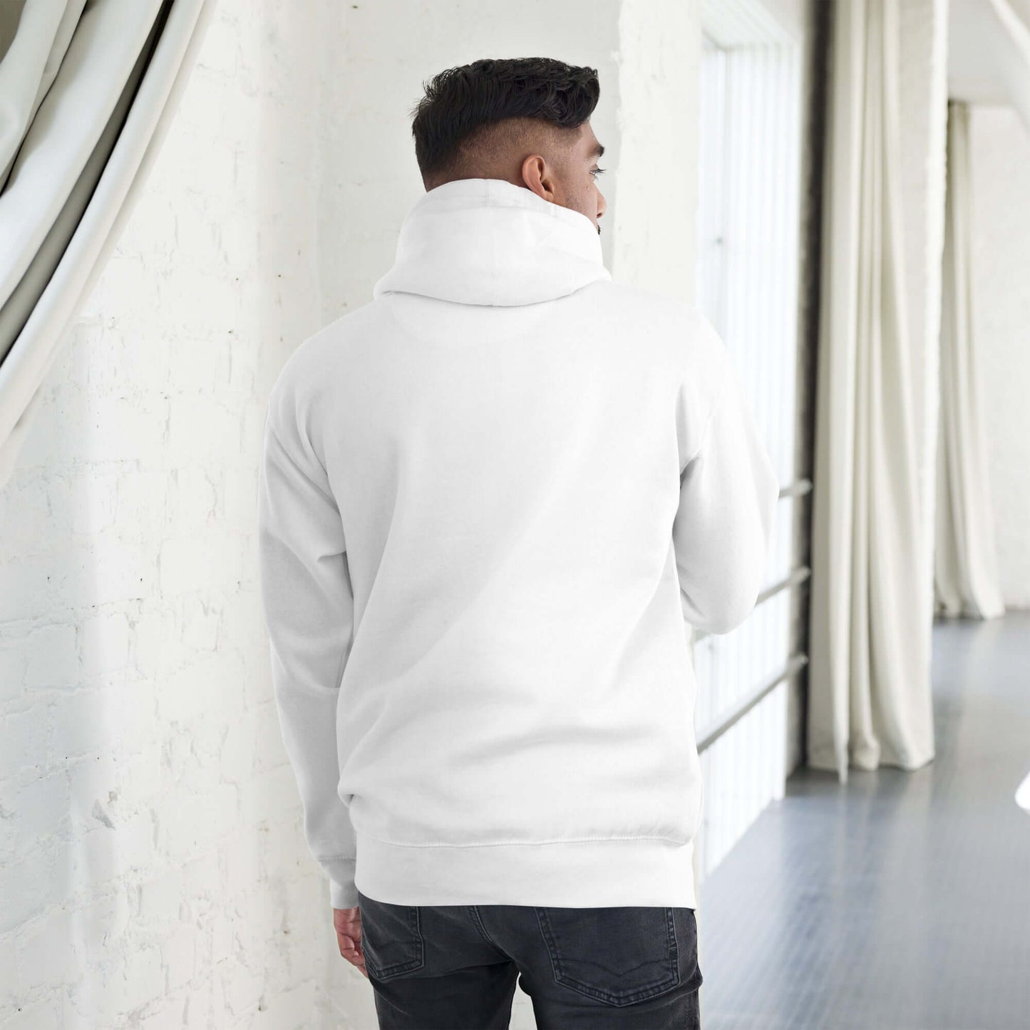 Person wearing Unisex-Kapuzenpullover N°49 in a modern setting, showcasing back design and comfortable fit.