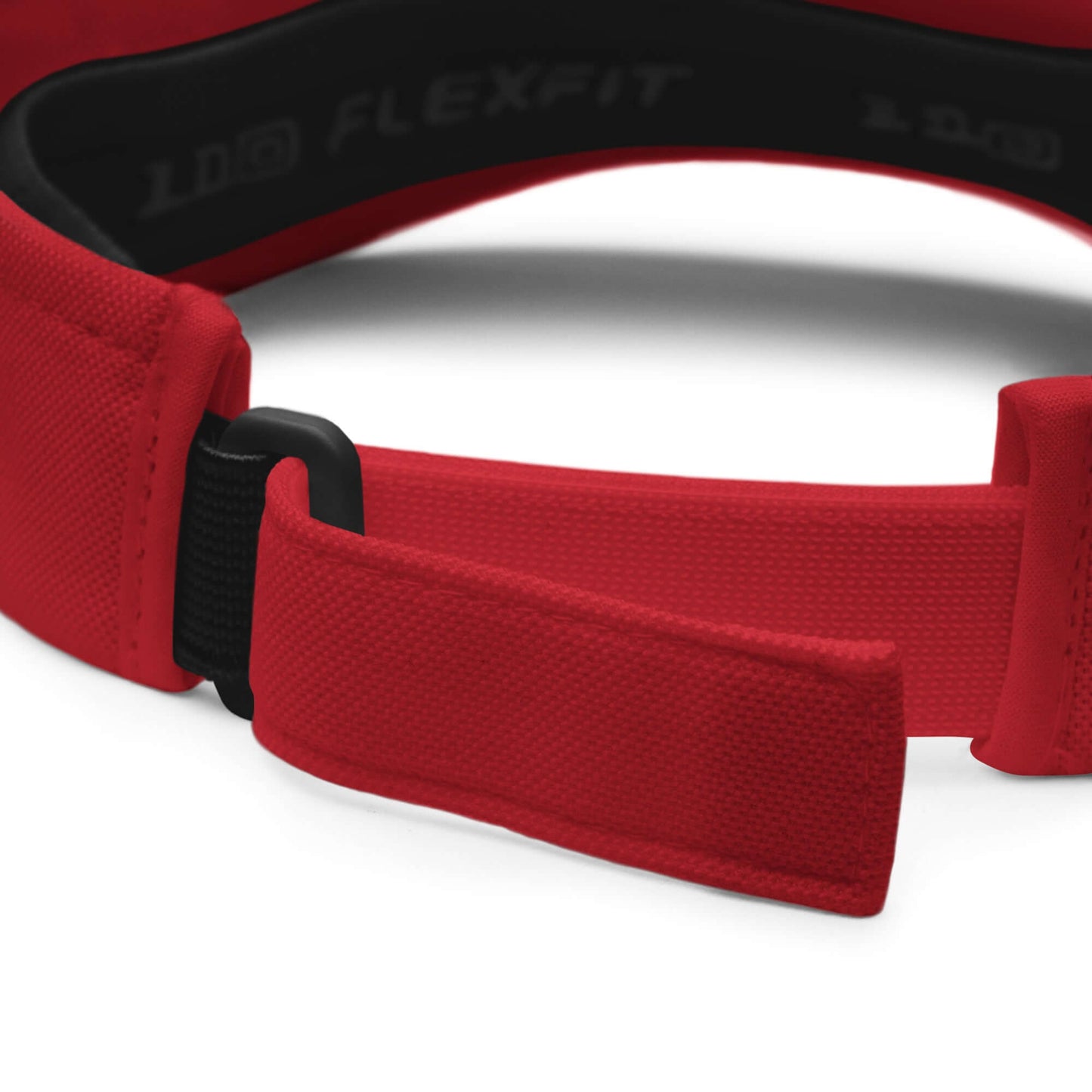 Adjustable red strap of Visor N°1 with moisture-absorbing fabric, Velcro closure, and Flexfit branding.