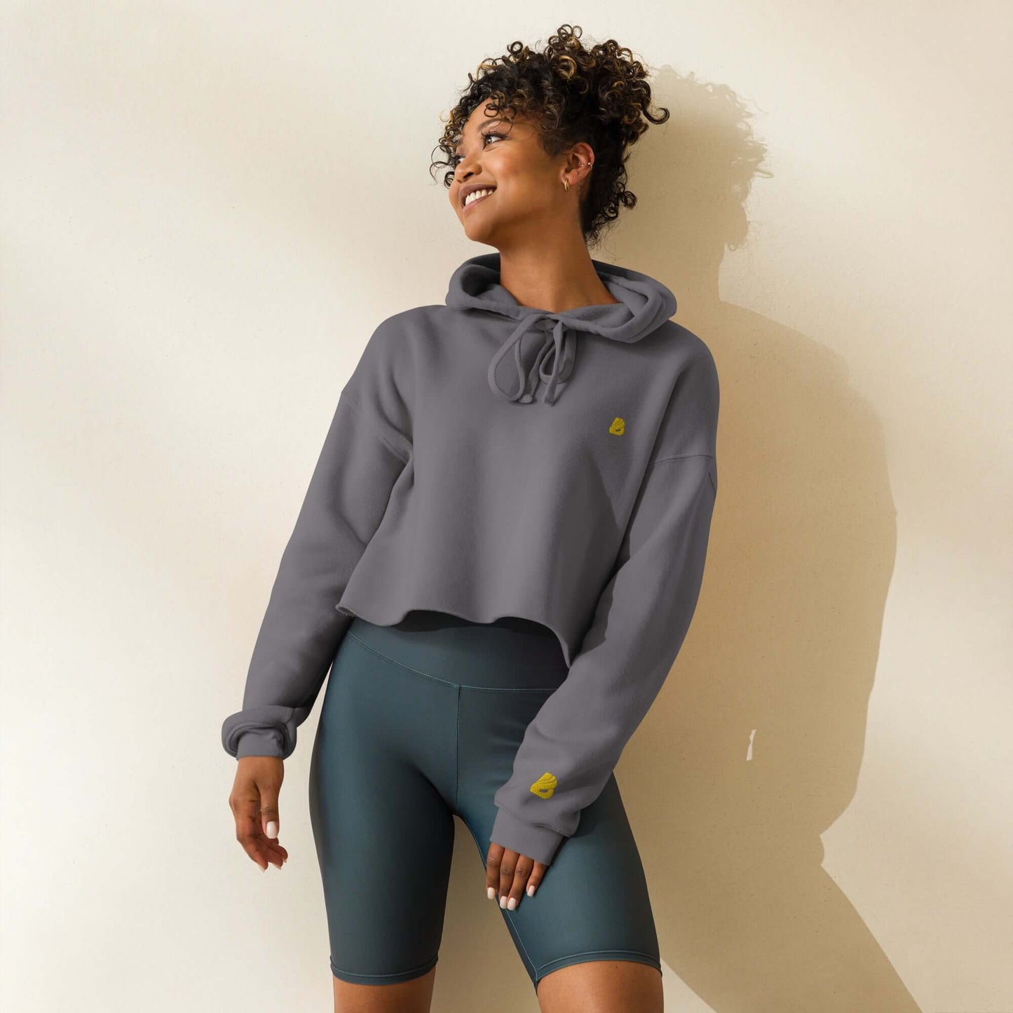 Woman wearing Crop-Hoodie N°1 with open hem and drawstrings, showcasing trendy and breathable design.