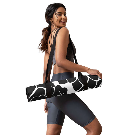 Woman carrying Yoga-Matte N°0 with floral design, wearing athletic gear, showcasing the mat's portability and style.